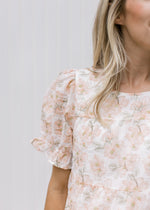 Close up of sheer puff short sleeves on a fully lined cream top with pink watercolor floral.