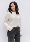 Model wearing a cream knit hoodie with a slightly cropped hem and long sleeves. 