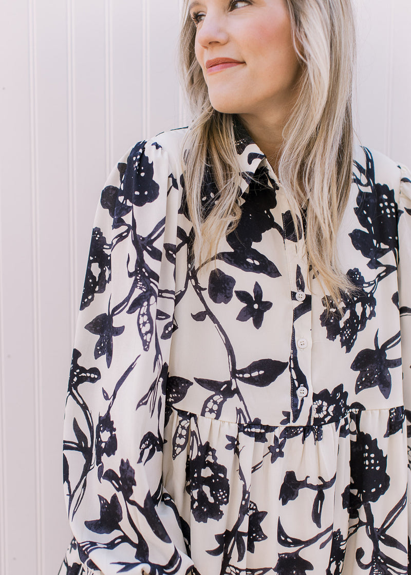 Close up of collar and buttons on the front of a cream midi with navy flowers and long sleeves.