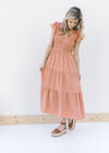 Model wearing heels with an apricot midi with a smocked bodice, ruffle capped sleeves and a v-neck.