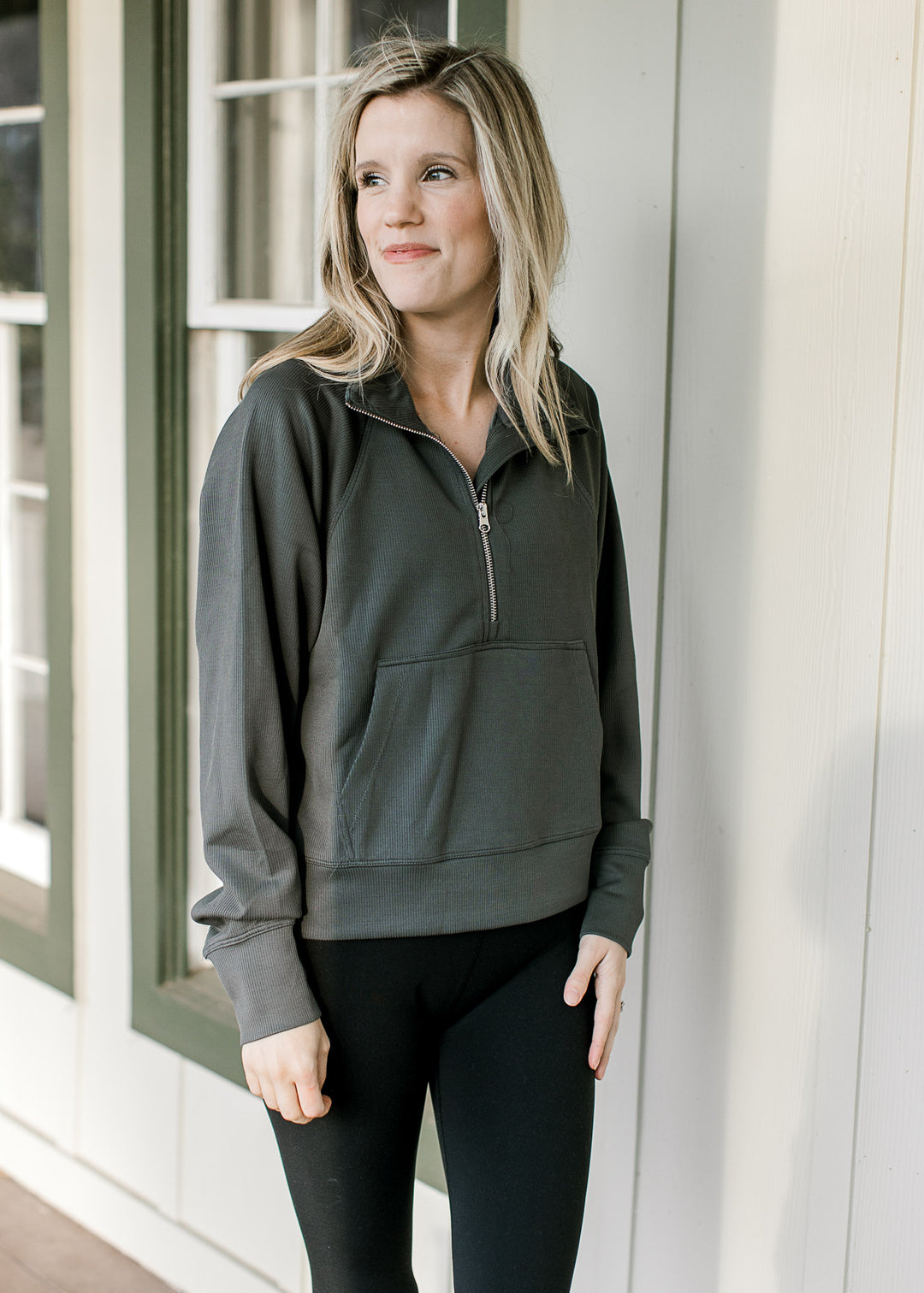 Model wearing leggings and an ash gray ribbed pullover with a front pouch pocket and long sleeves. 