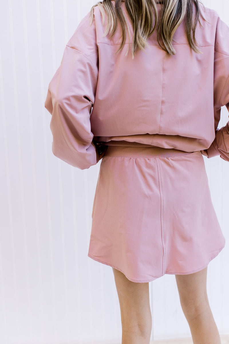 Back view of Model wearing a pink fleece lined skort with built in shorts and elastic waist.