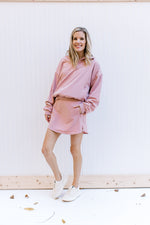 Model wearing a dust pink top with matching fleece skort with built in shorts and elastic waist.