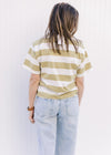 Back view of Model wearing an avocado and cream striped top with a crew neck and short sleeves.