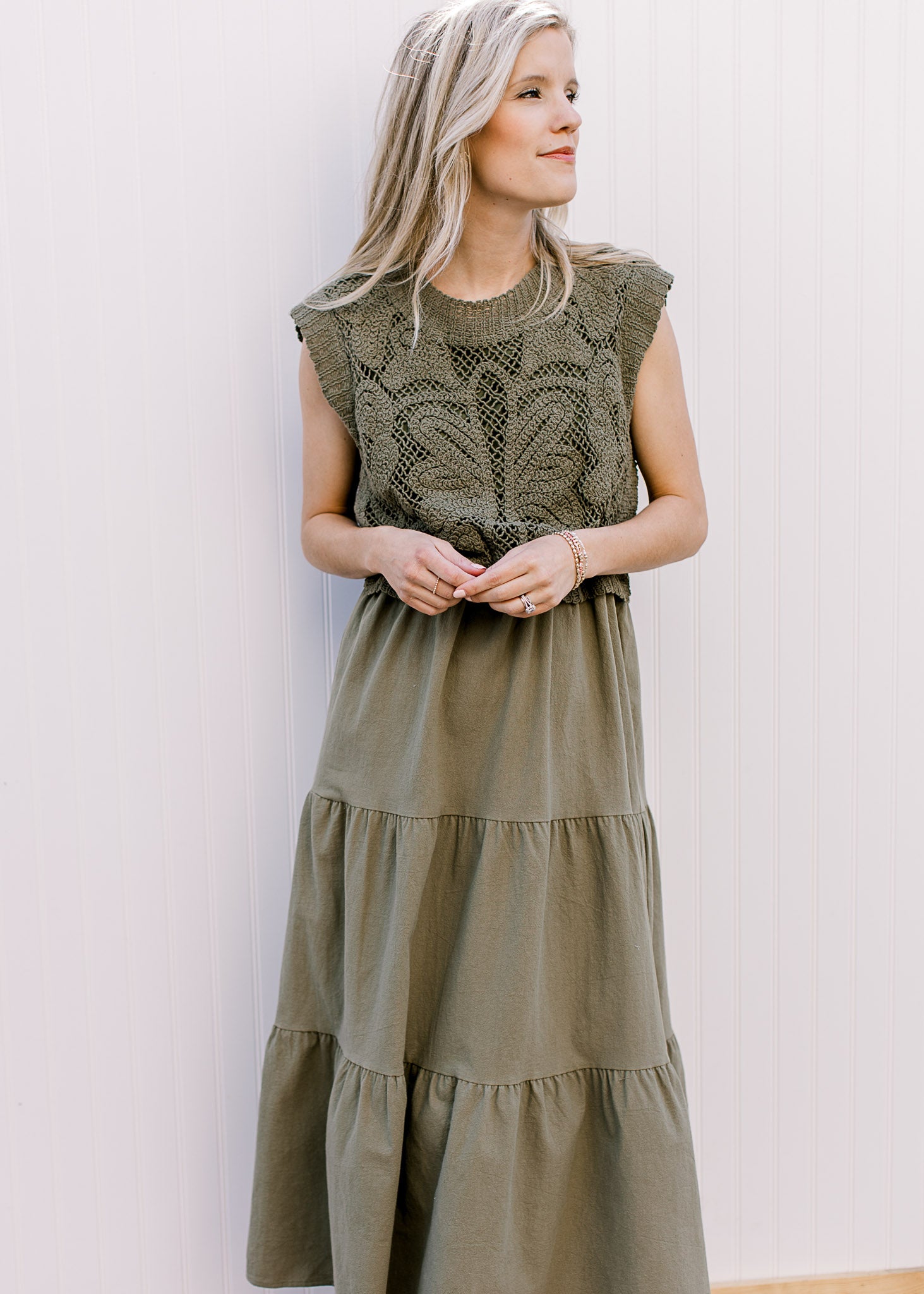 Model wearing a deep olive colored midi with lined openwork crochet top and capped sleeves. 