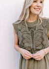 Close up of lined openwork crochet top on an olive midi with elastic waist and capped sleeves.