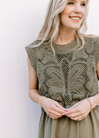 Close up of lined openwork crochet top on an olive midi with elastic waist and capped sleeves.