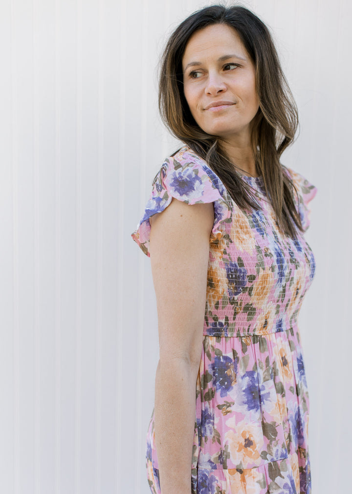 Side view of ruffle capped sleeves and smocked bodice on a lilac midi with a floral pattern.