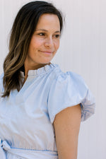 Close up of puff short sleeves and ruffle at the neck of a baby blue midi. 