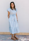 Model wearing wedges and a baby blue midi with v-neck and a tie at the waist.