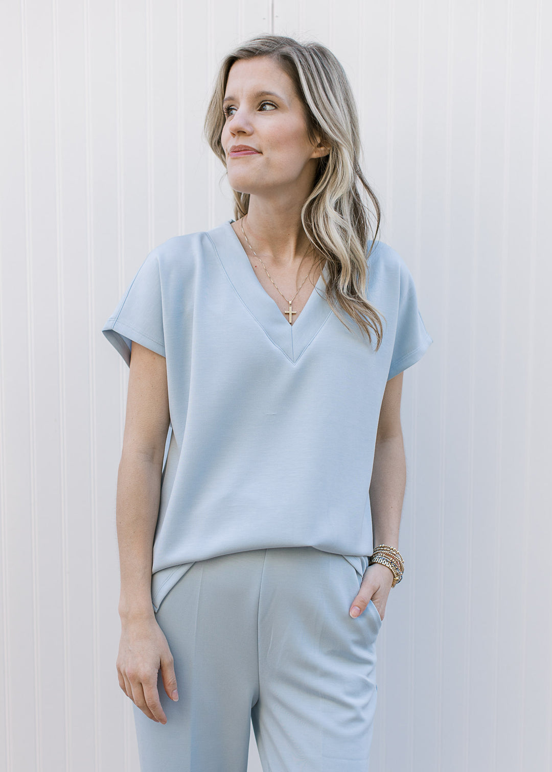 Close up on v-neckline and short sleeves on a baby blue matching set with wide leg bottoms. 