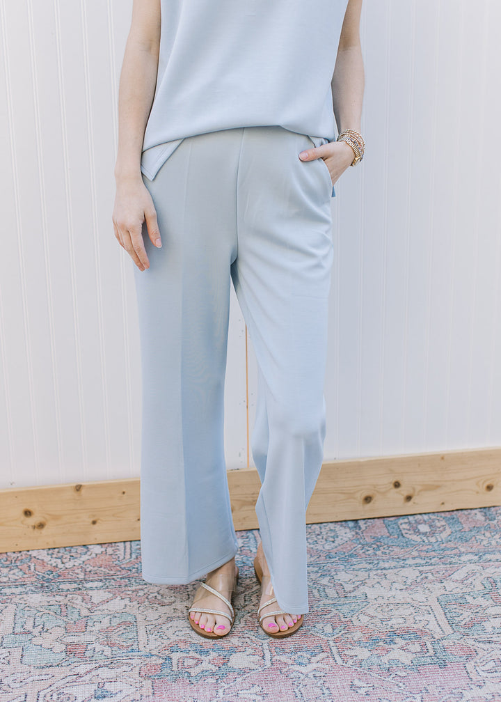 Close up of pale blue high-rise, wide leg pants with an elastic waist, pockets and a matching top. 