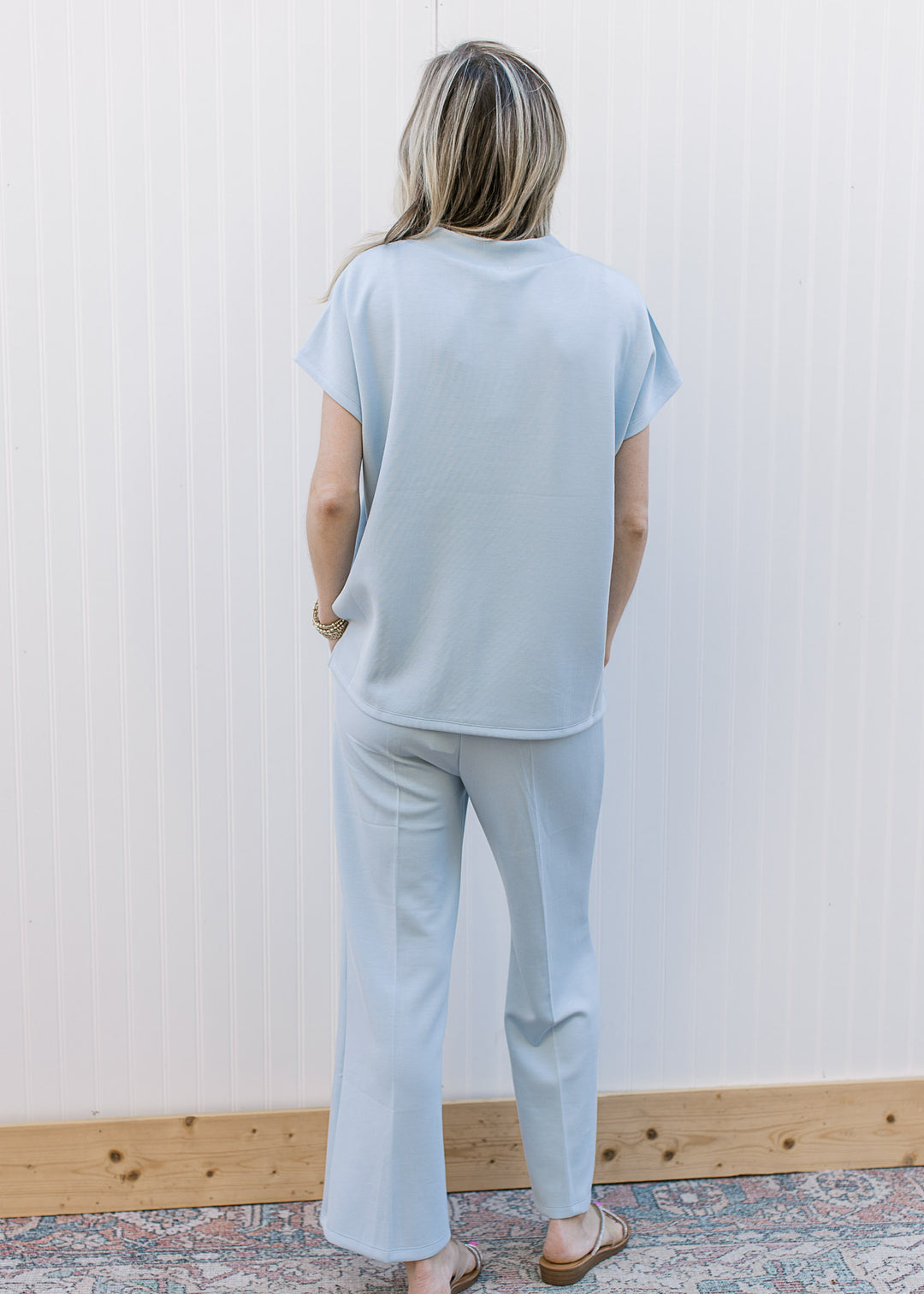 Back view of Model wearing a baby blue set with a short sleeve top and wide leg bottoms.