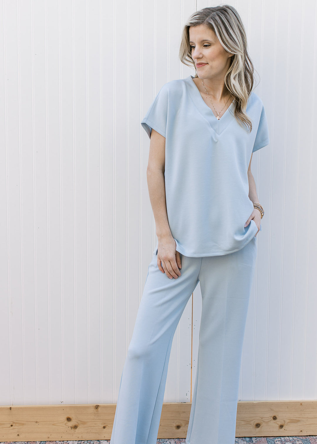 Model wearing a baby blue set the top has a v-neckline and short sleeves with wide leg bottoms.