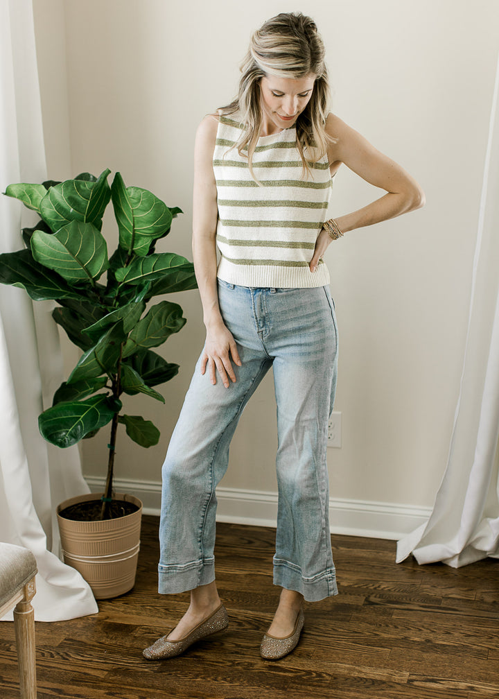 Model wearing jeans, flats and a cream sleeveless top with sage stripes and ribbon tie back. 