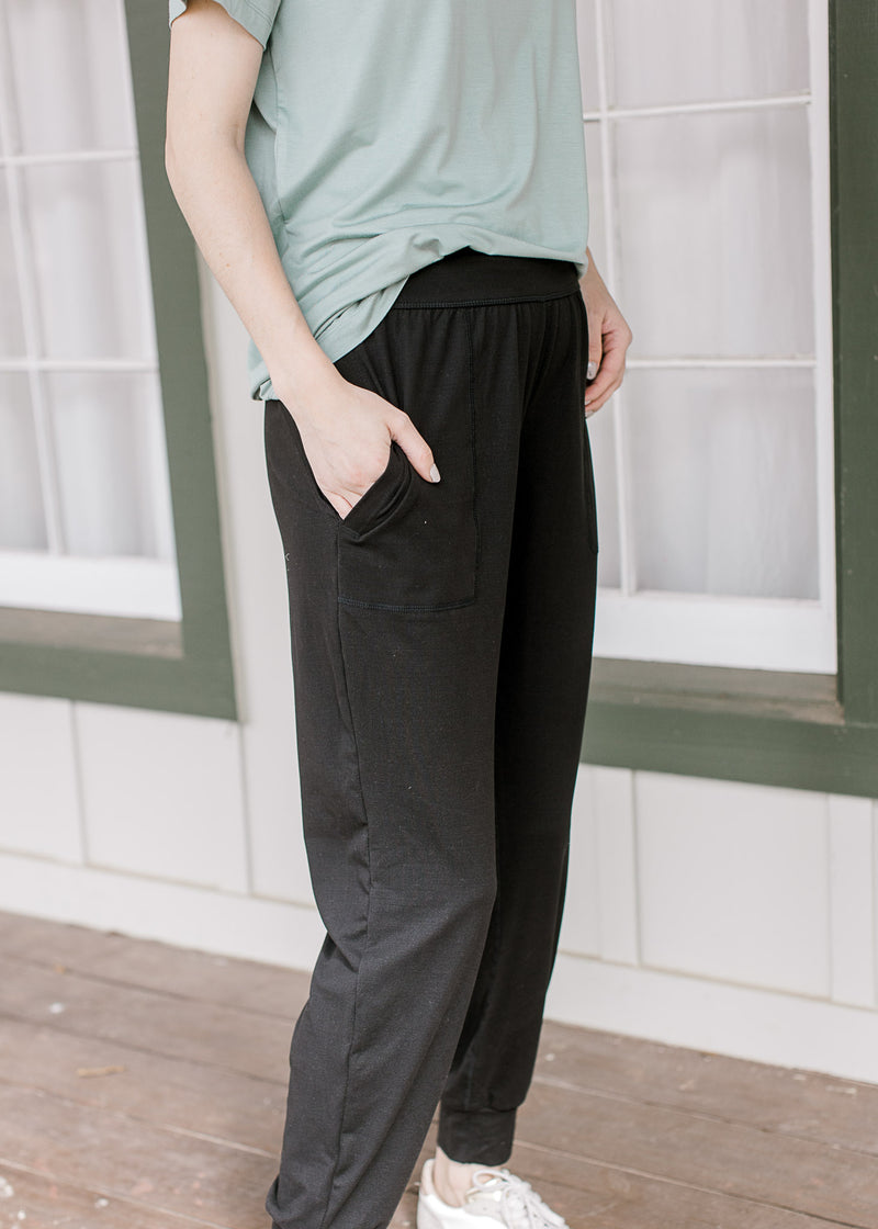 Side view of black, ultra soft joggers with patch front pockets and elastic high waist.