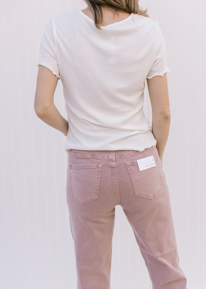 Back view of Model wearing a ivory ribbed top with ruffled at hem and short sleeve.