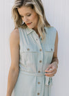 Close up of button front, patch pockets, tie waist and a collar on a soft basil sleeveless dress.  