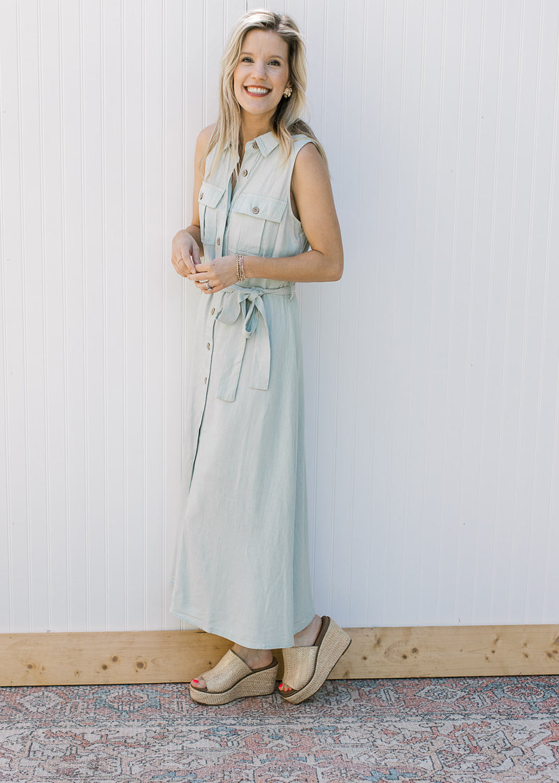 Model wearing a sleeveless, soft basil maxi with button front and a tie at the waist. 