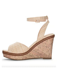 Inside view of tan heels with a padded footbed, delicate ankle strap, curved vamp, and wedge sole