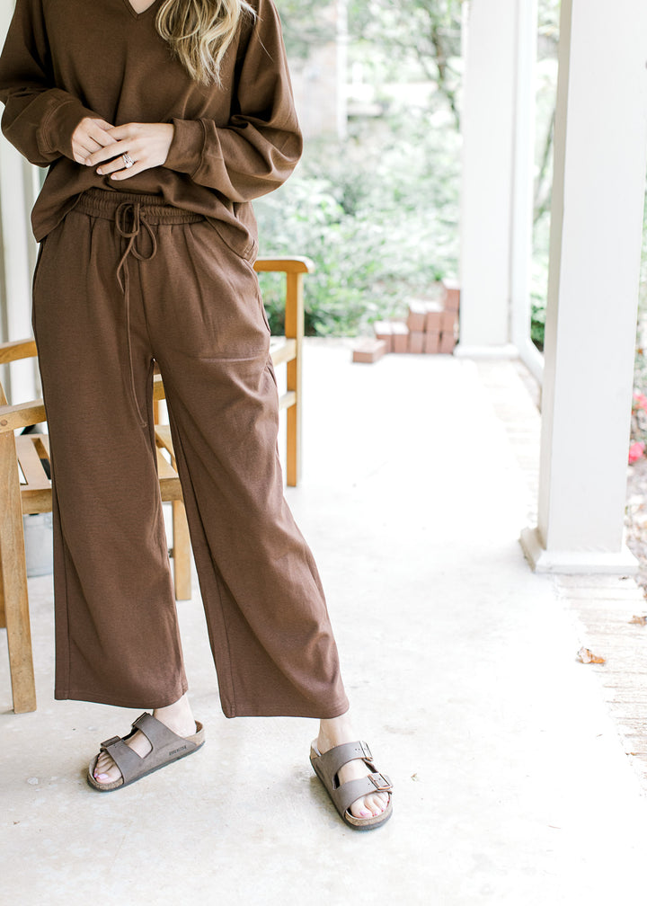 Close up of wide leg mocha bottoms with tie closure, pockets and elastic band