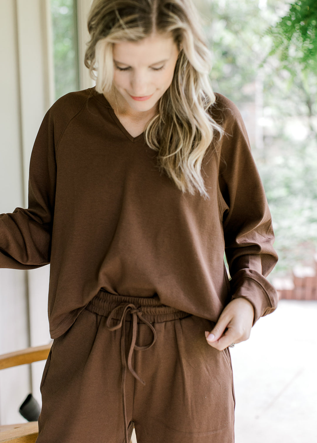 Close up of mocha sweatshirt with long sleeve and a v-neck with matching bottoms. 