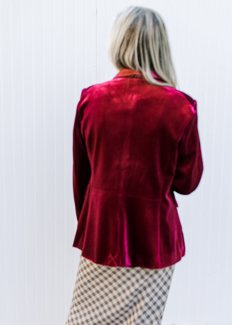 Back view of Model wearing a wine colored blazer with long sleeves and a single button closure. 