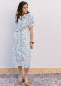 Model wearing sandals and a button front cream midi with pale blue floral and bubble short sleeves.