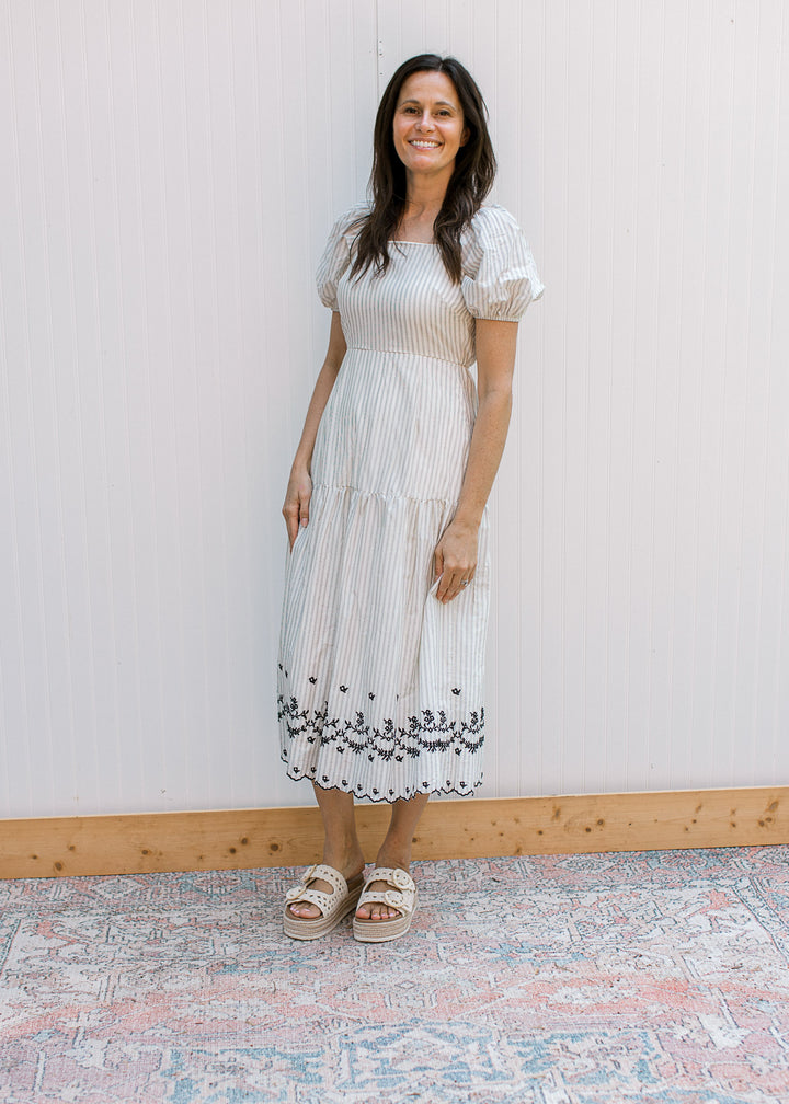 Model wearing sandals and a cream midi with gray stripes, square neck and bubble short sleeves.