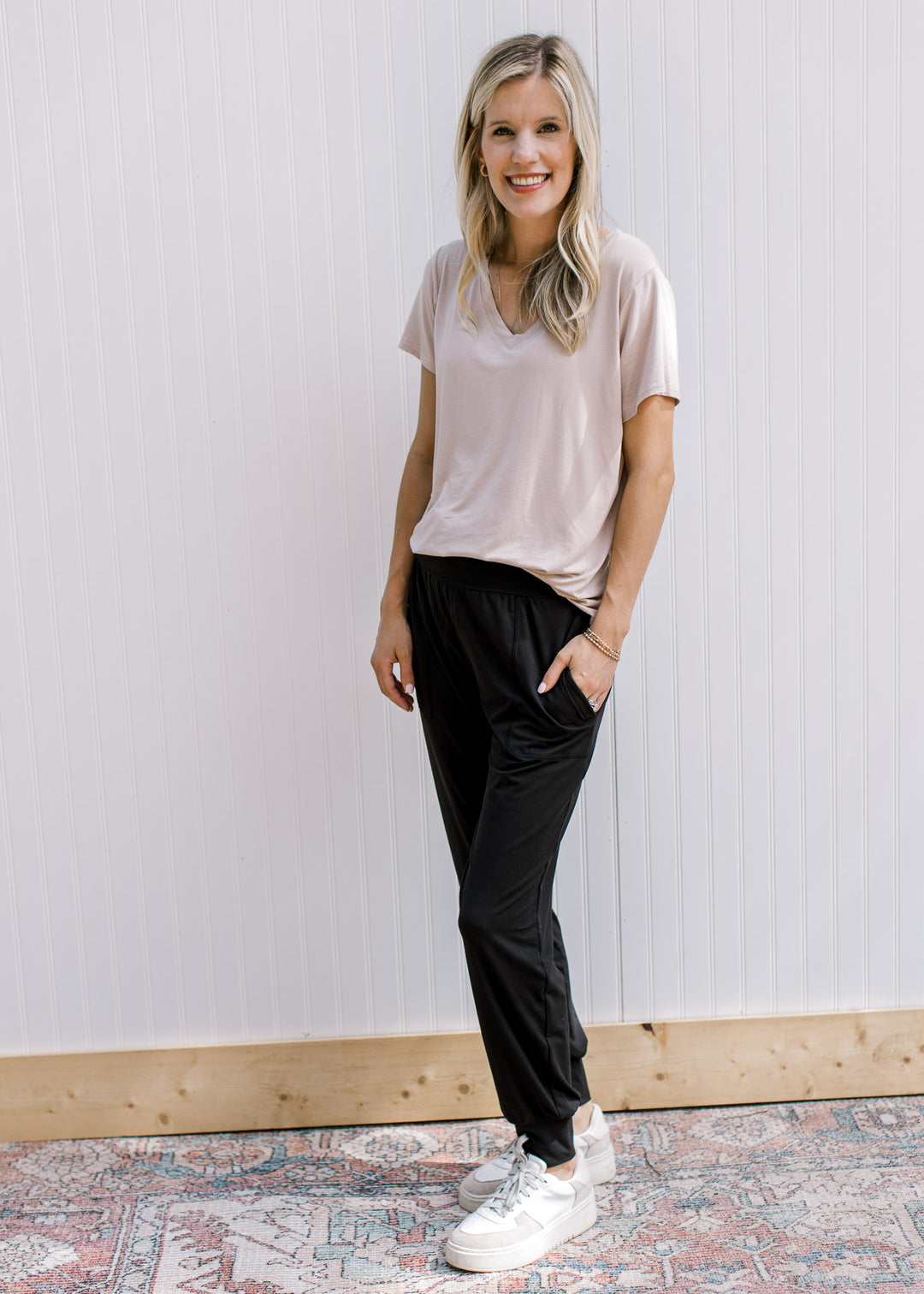 Model wearing black comfy athleisure joggers with elastic waist, pockets and stretchy material.