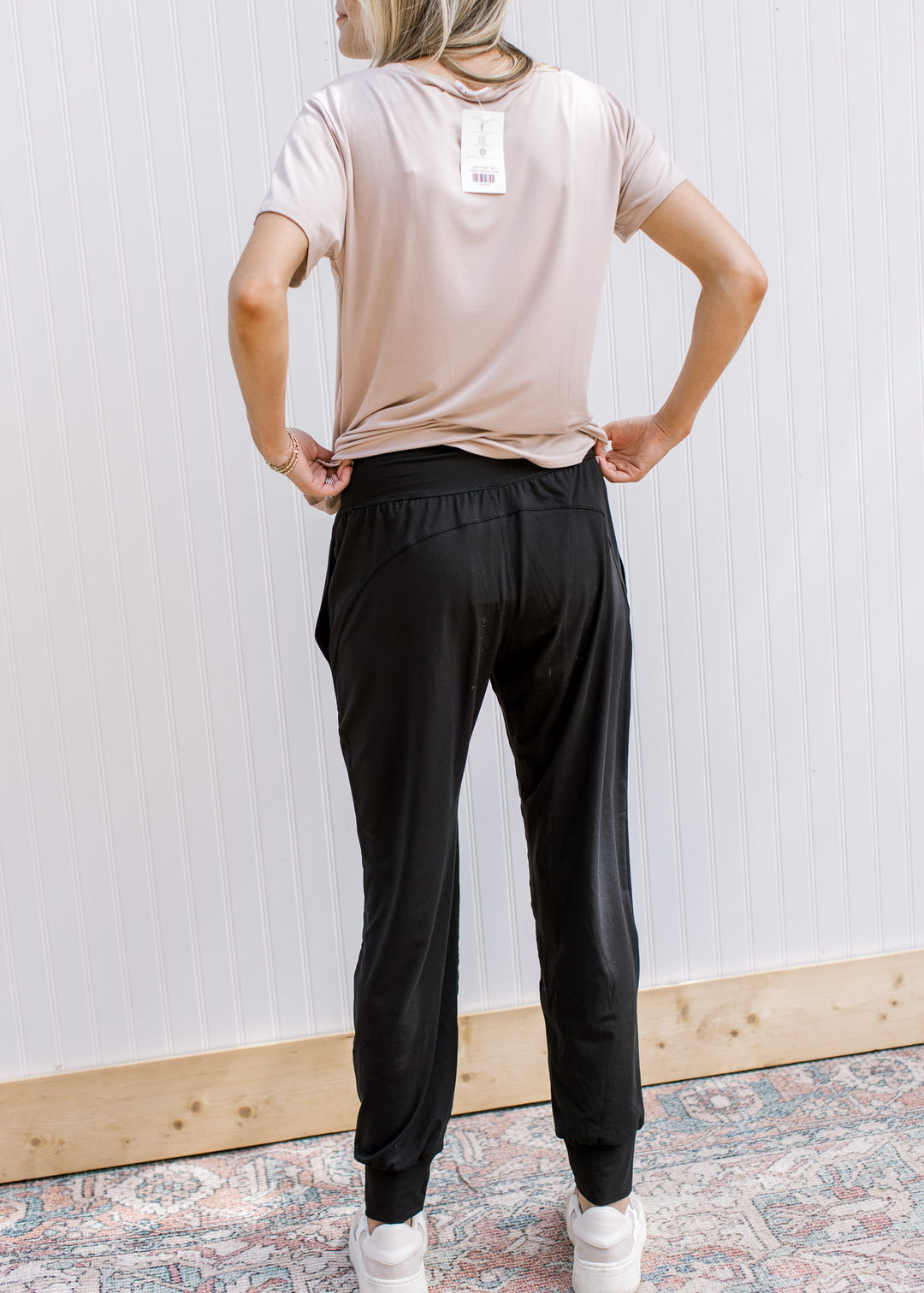 Back view of Model wearing black comfy athleisure joggers with elastic waist and stretchy material.