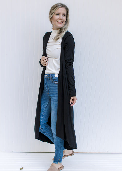 Model wearing a black long sleeve cardigan with a duster length and a bamboo viscose material. 