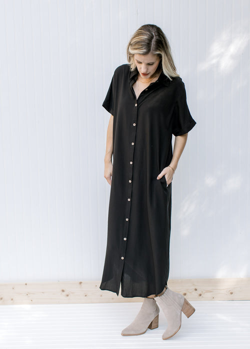 Model wearing booties with a black button up midi dress with short sleeves. 