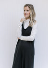 Close up of round neck and sleeveless design on a back jumpsuit with wide legs and pockets. 