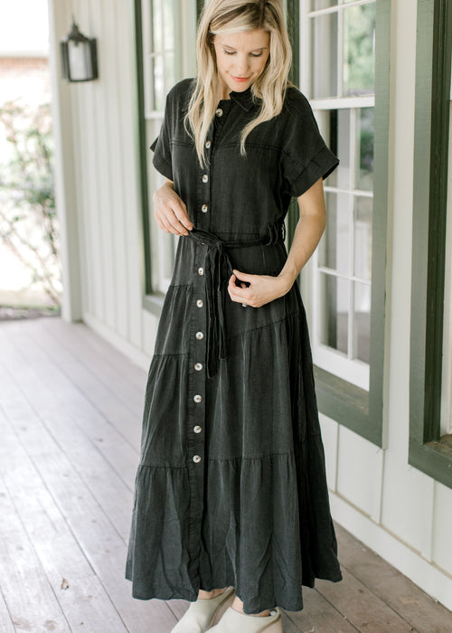 Model wearing a lightweight black washed denim maxi with button front and belt tie.