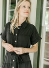 Close up of button front and short sleeves on a lightweight black washed denim maxi. 