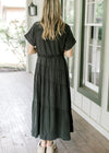 Back view of Model wearing a lightweight black washed denim maxi with button front and belt tie.