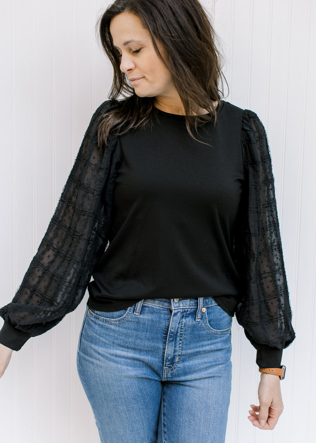 Model wearing a black top with a round neck and lace bubble long sleeves. 
