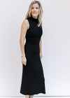 Model wearing a black sleeveless dress with a mock neckline, ribbed material and split side hem. 