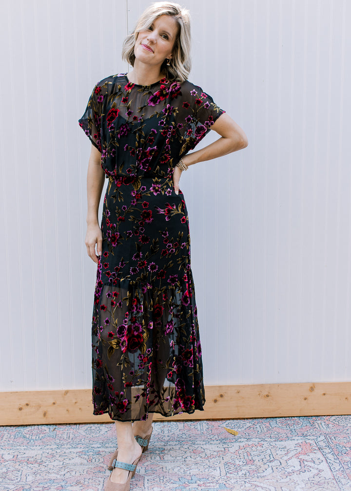 Model wearing a black midi with sheer overlay elastic waist, attached slip and short sleeves.