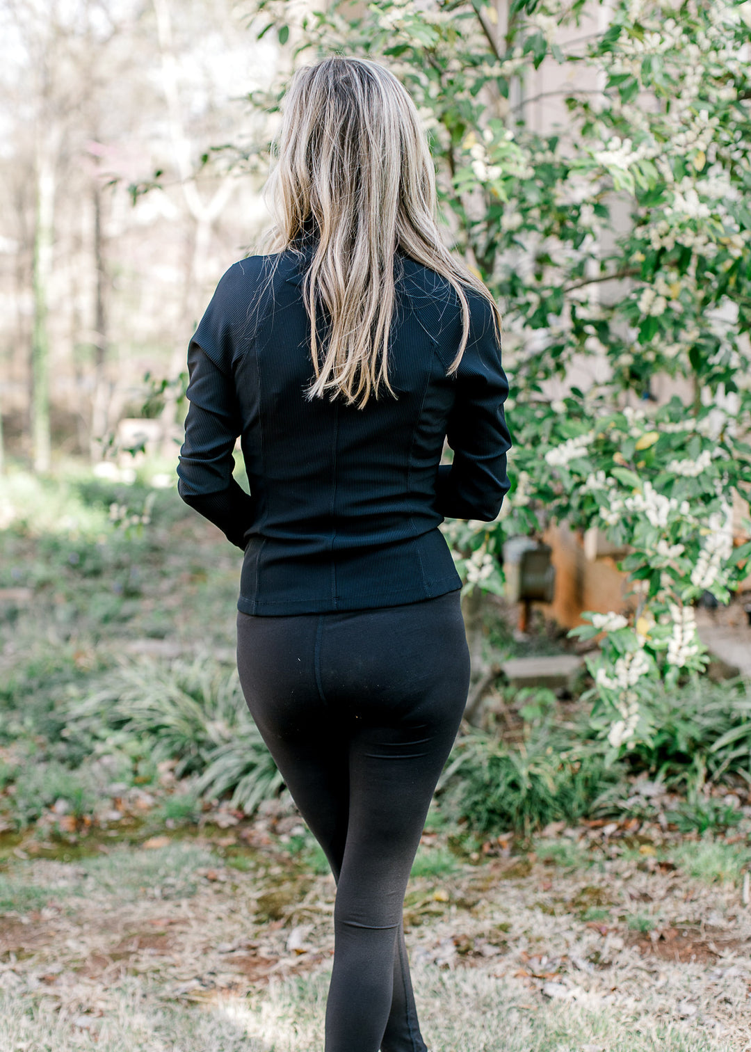 Back view of Model wearing black buttery soft leggings with full length and waistband pocket. 
