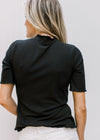 Back view of Model wearing a black ribbed fitted top with short sleeved and ruffle neck and hem.