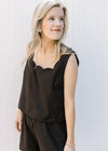 Close up of square neck on a black sleeveless top with matching shorts with elastic waist. 