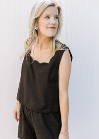 Close up of square neck on a black sleeveless top with matching shorts with elastic waist. 