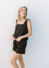 Model wearing a black set with a square neck tank, scalloping at neck and hem of top and shorts. 