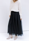 Model wearing booties with a black tulle maxi skirt with an elastic waist with a sheer overlay.