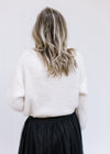 Close up of elastic waistband on a black tulle skirt with a sheer overlay and a maxi length. 