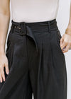 Model wearing hi rise, belted pants with pockets and wide legs. 