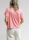 Back view of Model wearing an pink short sleeve top with a slightly cropped fit. 