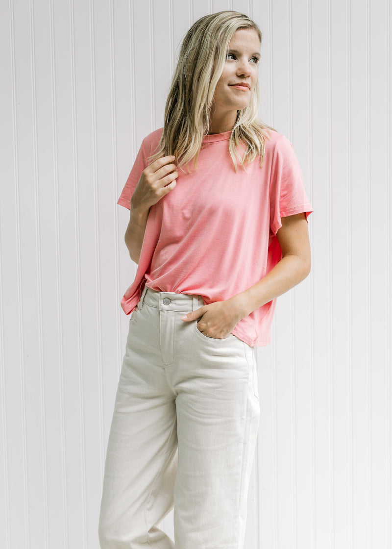 Model wearing khaki pants with a pink, cropped short sleeve top with a bamboo viscose material. 